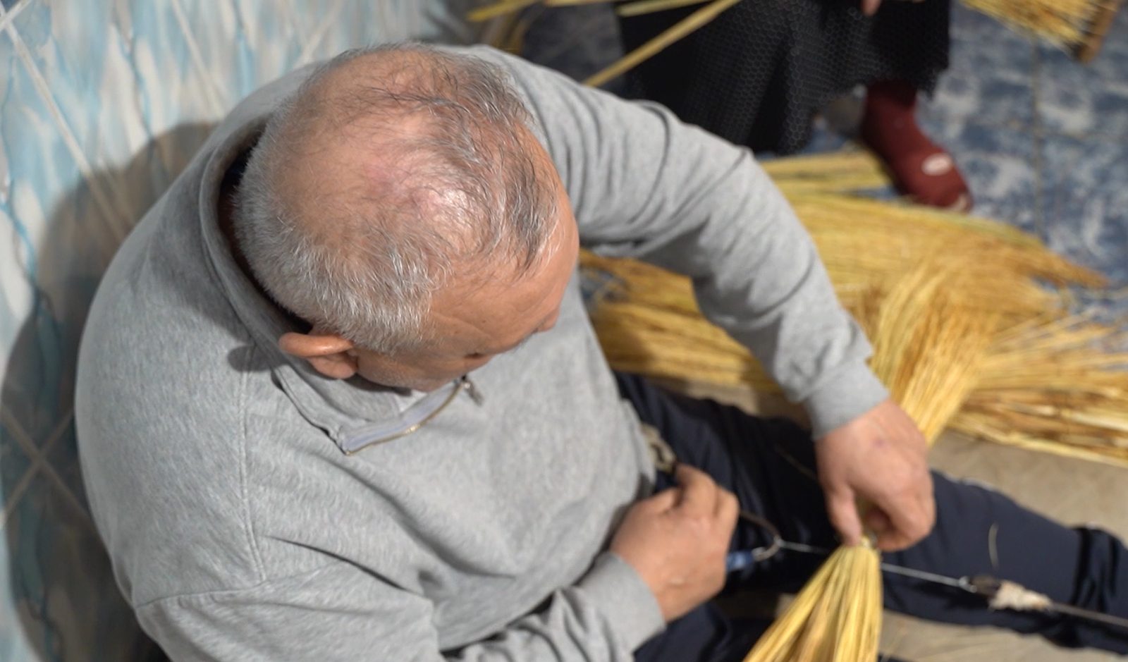 Cristian Ștefan tying a traditional broom at his workshop in Clejani